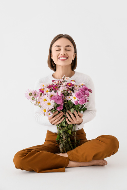 Pretty young woman with bouquet of flowers on white background - Foto, Imagem