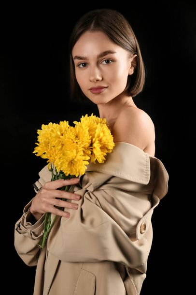 Sexy mladá žena s kyticí květin na černém pozadí - Fotografie, Obrázek