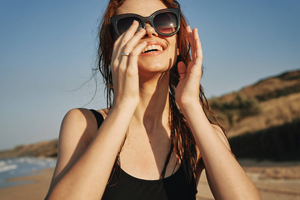 cheerful woman in sunglasses in a swimsuit on the beach sun island - Fotoğraf, Görsel
