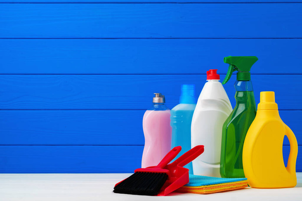 Various cleaning items against blue wooden background - Foto, Imagem