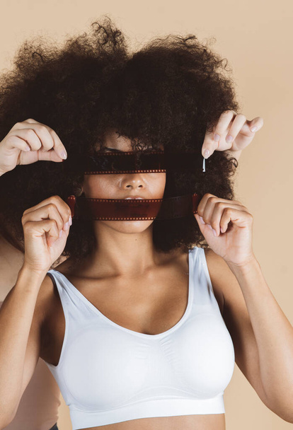 όμορφη αφρο-αμερικανίδα γυναίκα με φωτογραφικό φιλμ, αρνητική, φωτογραφία μόδας - Φωτογραφία, εικόνα