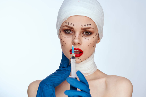beautiful woman in blue gloves syringe in hands contour on the face lifting isolated background - Фото, зображення