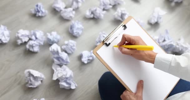 Woman writing business plan on paper among crumpled documents scattered on floor closeup 4k movie slow motion - Footage, Video