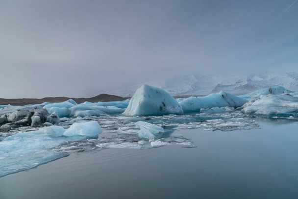 Háttér jéghegyekkel a jégmezőn egy lagúnában, sarkvidéki táj, Izlandon, Európában - Fotó, kép