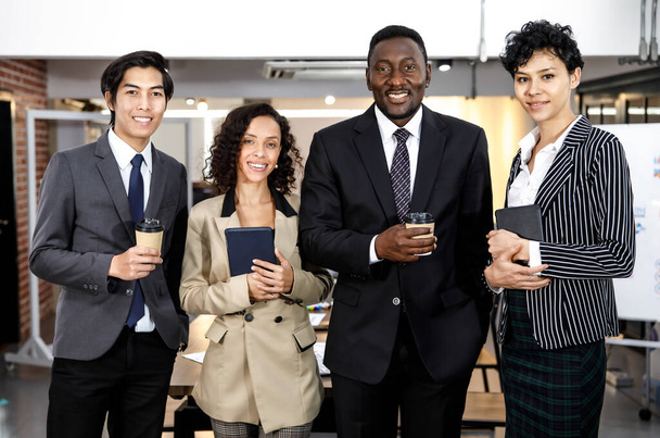 Portrait erfolgreiche intelligente gemischte Rassen oder multirassische Geschäftsleute oder Unternehmer in formalem Stil lächelnd, mit Selbstvertrauen und Professionalität stehend, mit einer Tasse Kaffee und einem Tablet in der Hand. Vielfältiges Teamkonzept. - Foto, Bild