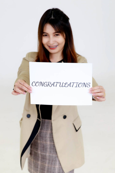 Studio shot of unrecognizable unidentified faceless female human resources staff officer in casual business wears stand hold congratulations paper sign cover face to new employee on white background. - Photo, Image