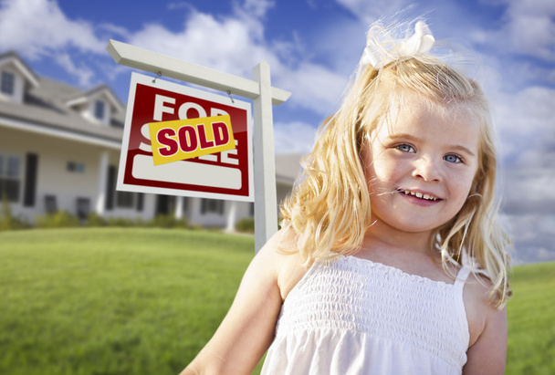 Cute Girl in Yard with Sold For Sale Real Estate Sign and House - Фото, изображение