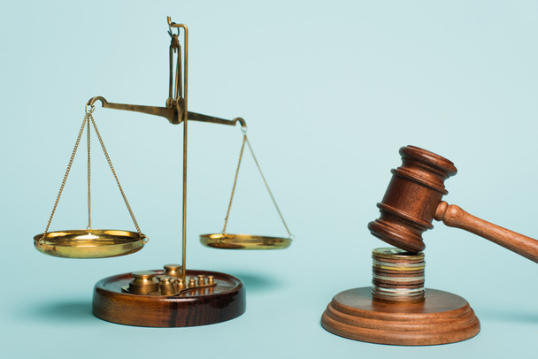 bronze justice scales, wooden gavel and coins on blue background, anti-corruption concept - Photo, Image