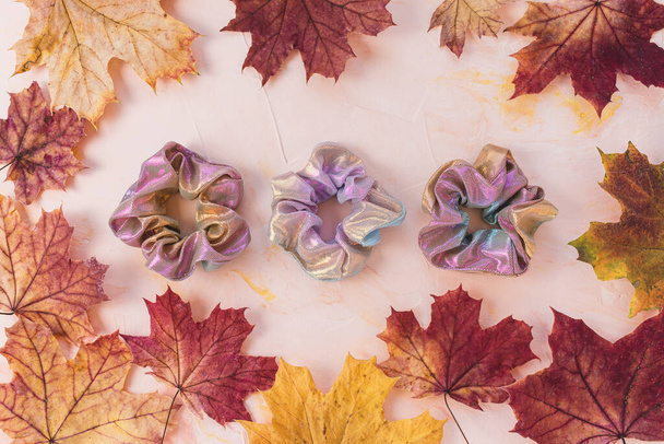 scrunchies olográficos metálicos rosados y hojas de arce de otoño - Foto, imagen