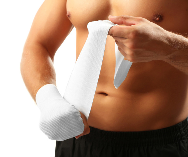 Красивий молодий м'язистий спортсмен з еластичною пов'язкою на руці ізольовано на білому
 - Фото, зображення