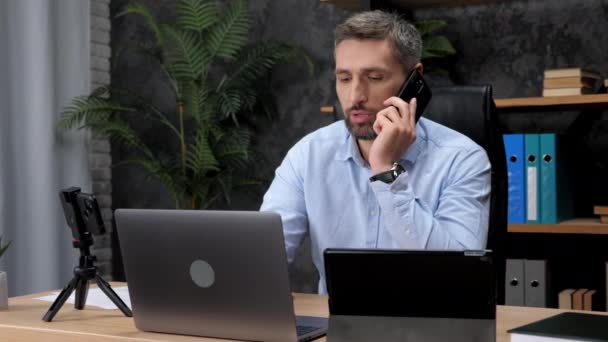 Muž obchodník mluví na mobilním telefonu s investorem společnosti na burze - Záběry, video