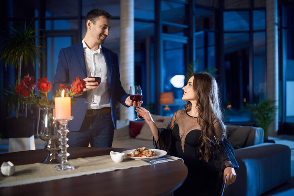Happy couple enjoying evening time at home with wine - Photo, Image