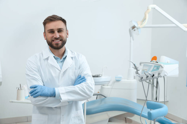 Portrait of professional dentist at workplace in clinic - Foto, imagen