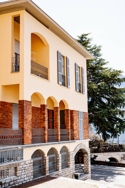 アーチ型の窓のあるヴィラのカラフルなファサード。イタリアのコモ - 写真・画像