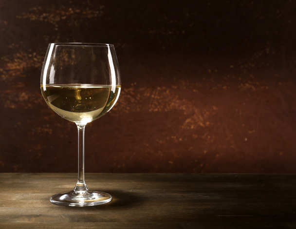 Goblet of white wine on wooden table on wooden wall background - Valokuva, kuva