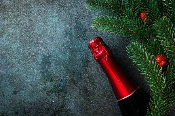 Şampanya şişesi ve Noel dekoruyla yeni yıl kompozisyonu. Yeni Yıl 'da. Noel beşiği. Yeni yıl 2022. Koyu arkaplanda Noel dekoru ve oyuncaklarından yapılmış bir çerçeve. Üst görünüm, alanı kopyala. - Fotoğraf, Görsel