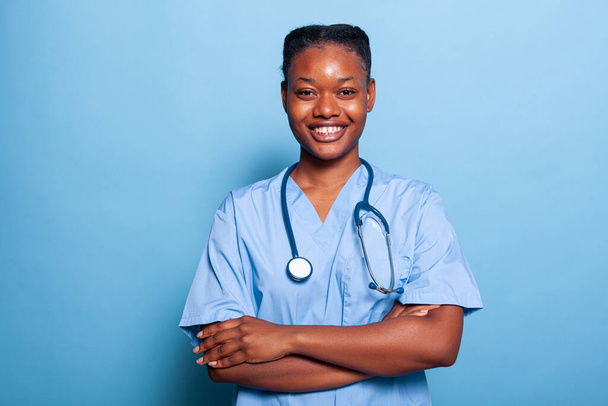 Retrato de enfermera practicante afroamericana sonriendo a la cámara trabajando en la experiencia de la enfermedad - Foto, imagen
