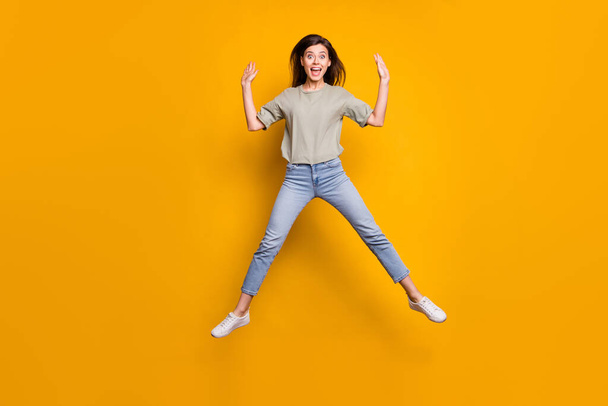 Full size photo of happy cute shocked girl jump up air raise hands dream sale isolated on yellow color background. - Foto, Imagen