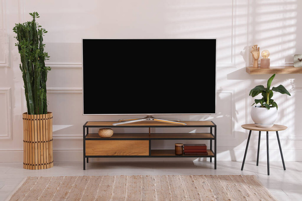 Modern TV on stand near white wall indoors. Interior design - Fotoğraf, Görsel