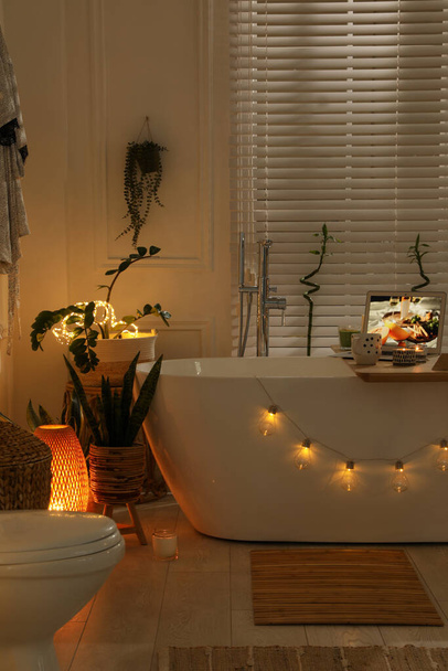 Stylish bathroom interior with green houseplants and string lights. Idea for design - Foto, imagen