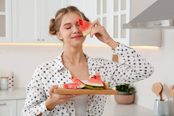 Beautiful teenage girl with slices of watermelon in kitchen - Foto, Imagem