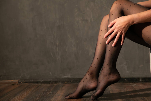 Женщина носит черные колготки на стройных красивых ногах - Фото, изображение