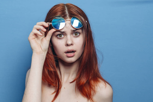 perky red-haired woman in blue glasses bare shoulders posing - Foto, Imagem