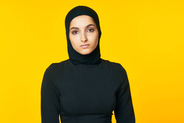 woman in muslim clothes posing islam yellow background - 写真・画像
