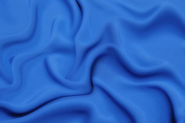 Nahaufnahme Textur aus natürlichem blauem Stoff oder Stoff in Gezeitenwasserfarbe. Textur aus natürlichem Baumwoll- oder Leinengewebe. Blauer oder grüner Canvas Hintergrund. - Foto, Bild