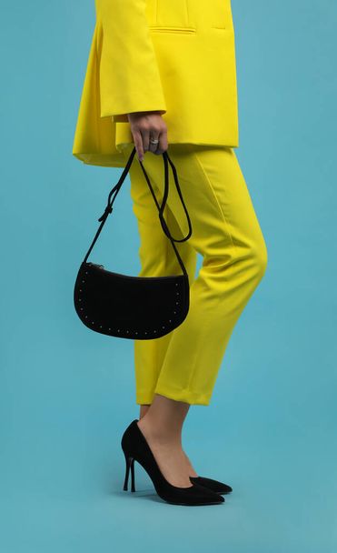 Fashionable woman with stylish bag on light blue background, closeup - Photo, Image
