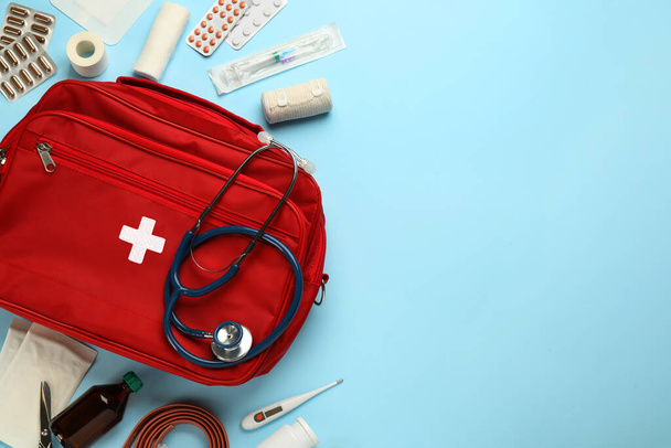 Flat lay composition with first aid kit on light blue background, space for text - Foto, Bild