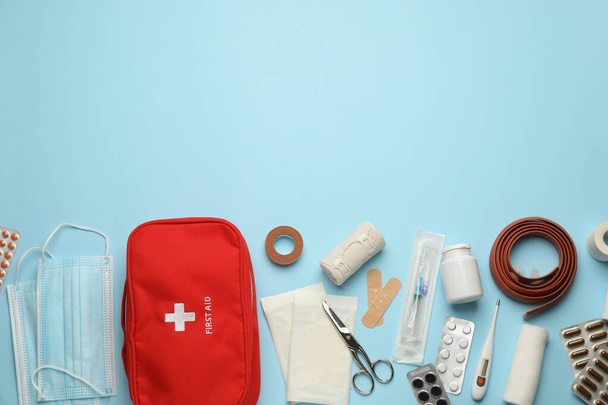 Flat lay composition with first aid kit on light blue background, space for text - Фото, изображение