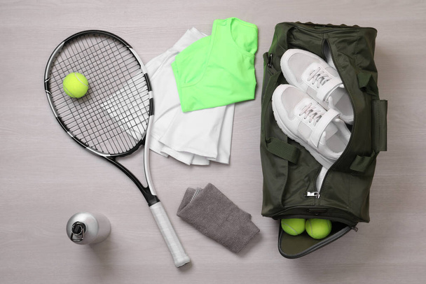 木製の背景にスポーツバッグやテニス用品、フラットレイアウト - 写真・画像