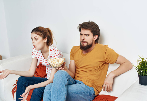 молодая пара дома, на диване, смотрит кино каникулы - Фото, изображение