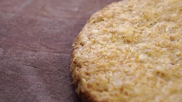 Round oatmeal cookies on a wooden surface. Macro. Textured baked surface. Slow rotation - Filmagem, Vídeo