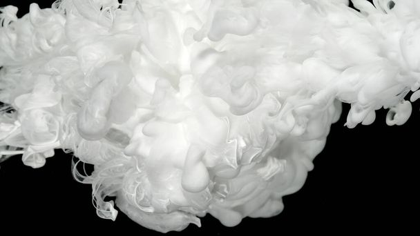 White acrylic ink in water on a black background. Environmental pollution concept. White cloud of ink. Relaxing meditative background. Beautiful milky white awesome abstract background. - Фото, изображение