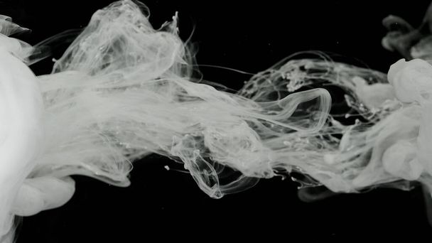 White acrylic ink in water on a black background. Environmental pollution concept. White cloud of ink, white smoke. Meditative background. Beautiful milky white awesome abstract background. - Foto, Bild