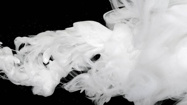 White acrylic ink in water on a black background. Environmental pollution concept. Meditative background. Beautiful milky white awesome abstract background. White cloud of ink. - Foto, imagen