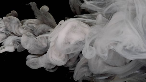 White cloud of ink. White and black acrylic paints are mixed in water on a black background. Beautiful milky white and black awesome abstract background. - Foto, Imagem