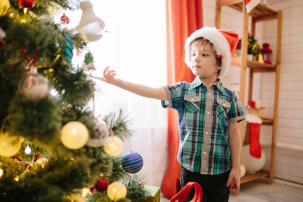 Cute Boy decorate the Christmas tree - Foto, afbeelding