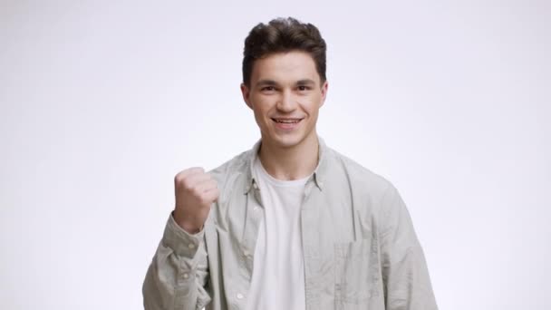 Achievement and win. Young confident man showing YES gesture, enjoying his victory, posing to camera with folded arms - Footage, Video