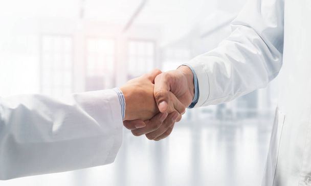 Close-up of the handshake between the two medics. Against the backdrop of the cityscape - Foto, imagen