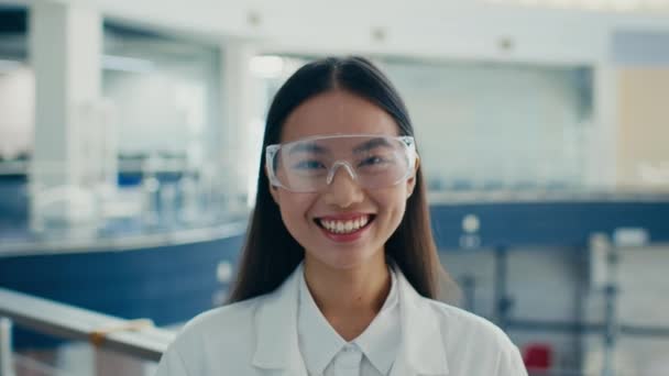 coreano produzione femminile tecnico indossa occhiali protettivi ridendo in piedi all'interno - Filmati, video