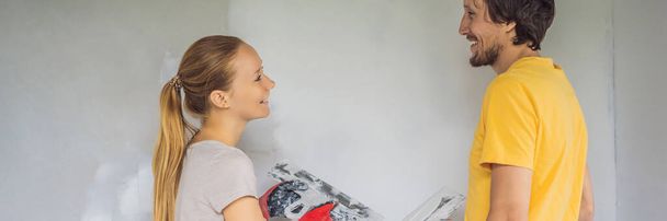 Nějaký muž a žena oblepují zdi domu. DIY renovace domu BANNER, DLOUHÝ FORMÁT - Fotografie, Obrázek