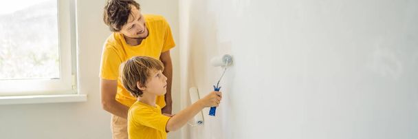 Father and son painting a wall in their home do it in the course of moving in BANNER, LONG FORMAT - Zdjęcie, obraz