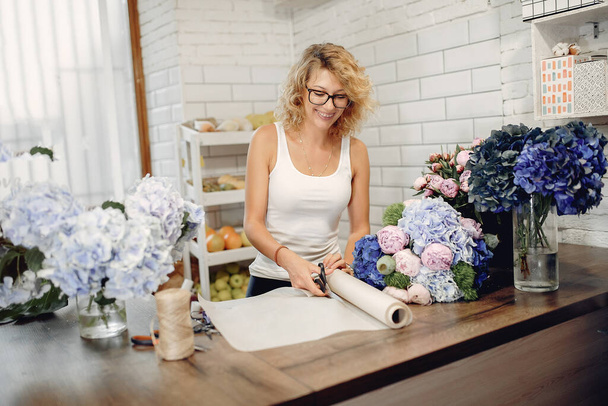 Florist in a flower shop making a bouquet - Foto, Imagem