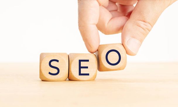 SEO or search engine optimization concept. Human hand holding a wooden block with text. Copy space - Φωτογραφία, εικόνα