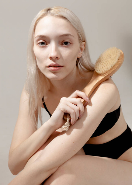 portrait of a beautiful girl with a massage brush in her hands - Fotoğraf, Görsel