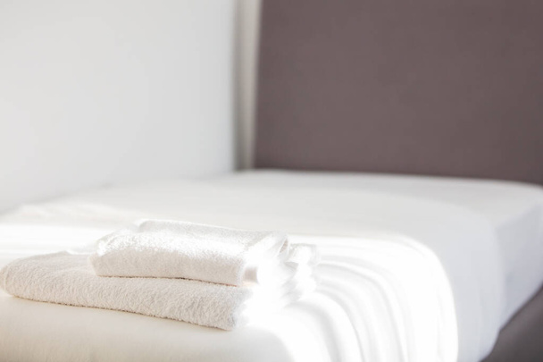 White clean towels stacked on the hotel bed - Foto, imagen