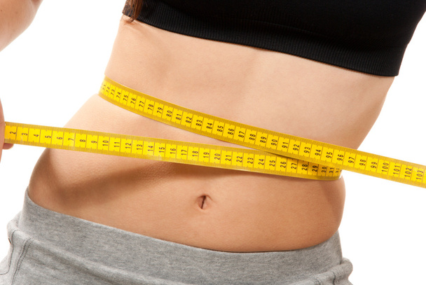 Athletic fit slim female measuring waist - Foto, Imagen